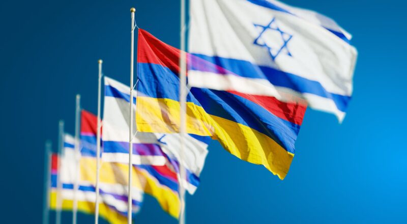 armenia and israel flags against blue sky